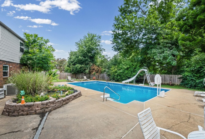 In-ground swimming pool with concrete surround