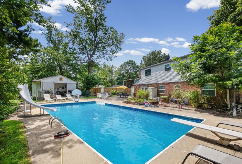 Expansive inground swimming pool with a diving board and slide