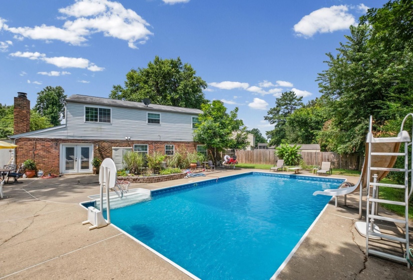 Expansive backyard featuring an in-ground swimming pool with concrete surround