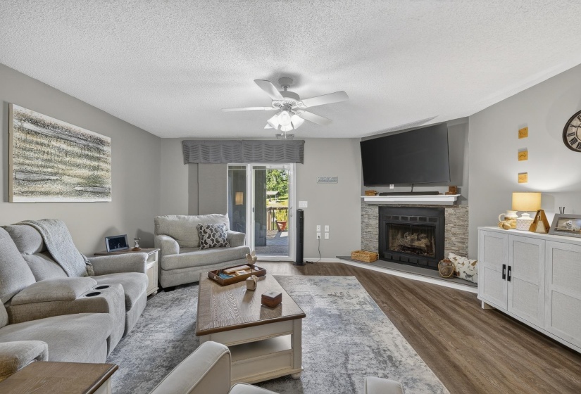 Living area featuring a corner fireplace with stone surround andn gas logs