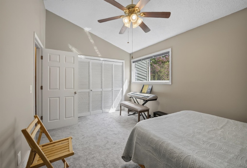 Room featuring a vaulted ceiling with a ceiling fan light fixture