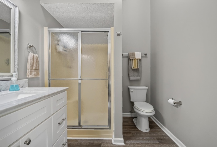 Bathroom featuring a white vanity with a marble-finish countertop and an integrated sink