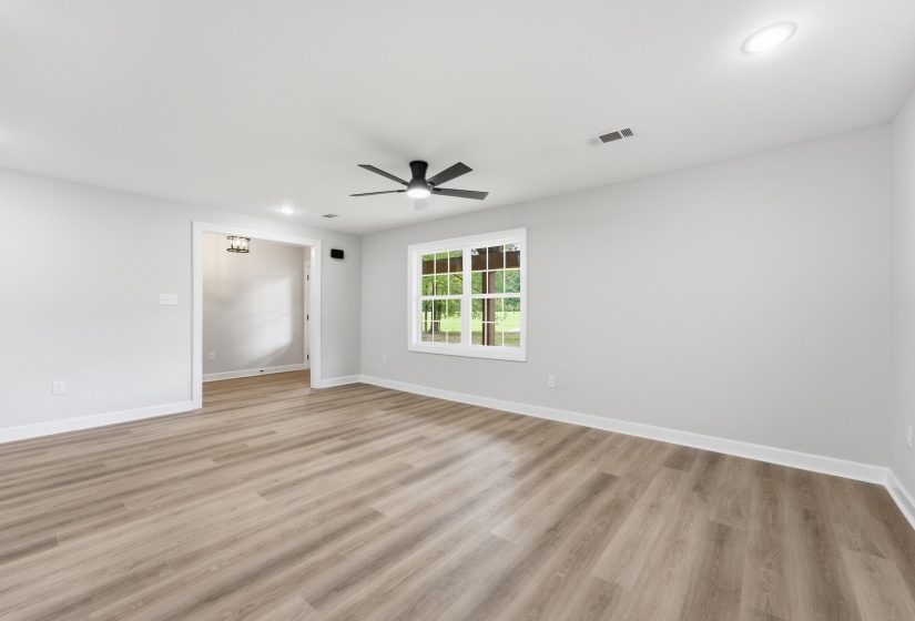 Spacious interior featuring wood-finish flooring, white baseboards, and light gray walls