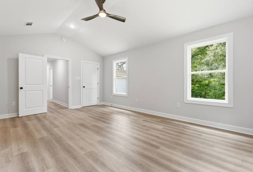 Spacious room featuring vaulted ceilings, recessed lighting, a ceiling fan, and wood-finish flooring