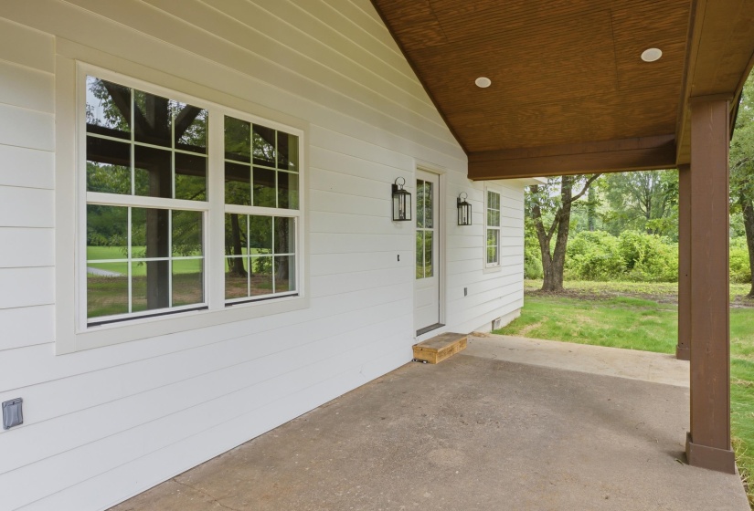 White horizontal siding exterior with a covered concrete patio