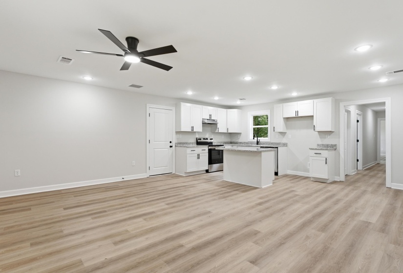 Open-concept living area featuring wood-finish flooring, recessed lighting, and a contemporary ceiling fan