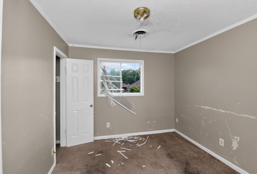 Interior room featuring a single window, a standard door, and a ceiling fixture