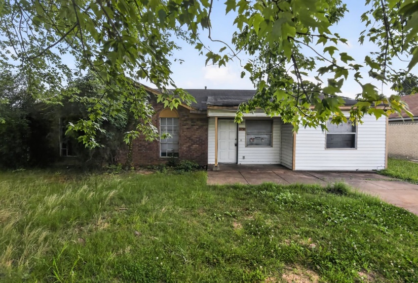Brick and siding exterior featuring multiple windows and a front entrance
