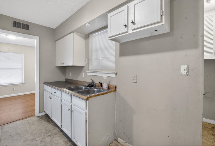 Kitchen featuring a double stainless steel sink, lower cabinetry, and upper cabinetry