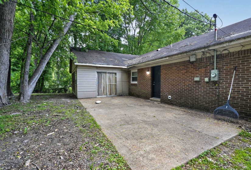 Concrete patio extending from the brick and siding exterior