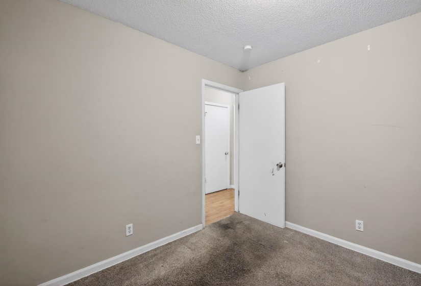 Room featuring neutral painted walls, textured ceiling, and gray carpet flooring