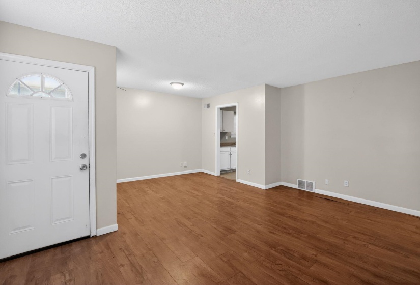Spacious interior featuring wood-finish flooring, light neutral wall paint, and white trim