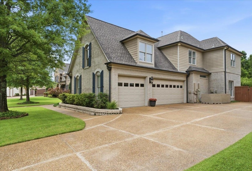 Two-story residence featuring a multi-car garage, dormer windows, and a combination of siding and brick exterior