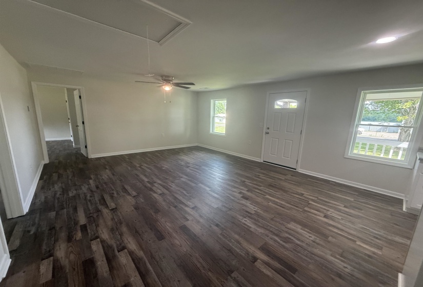 Spacious interior featuring wood-finish flooring, white walls, and bright windows