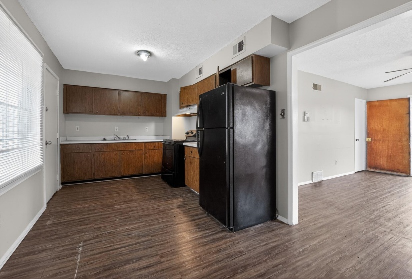 Kitchen featuring black appliances, light countertops, dark wood-style flooring, under cabinet range hood, and a ceiling fan