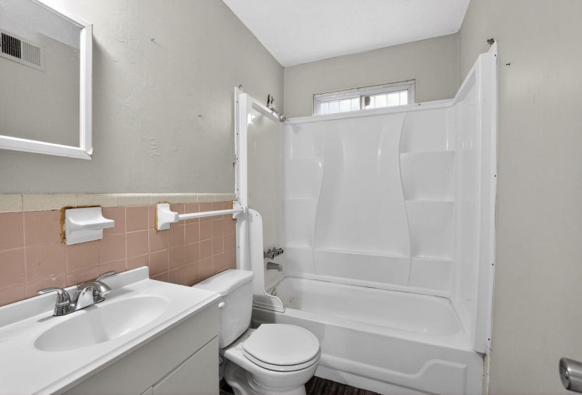 Bathroom with  shower combination, vanity, tile walls, and wainscoting
