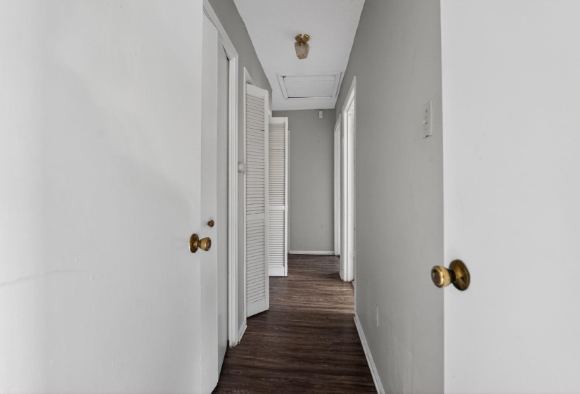 Hall with dark wood-style flooring and attic access