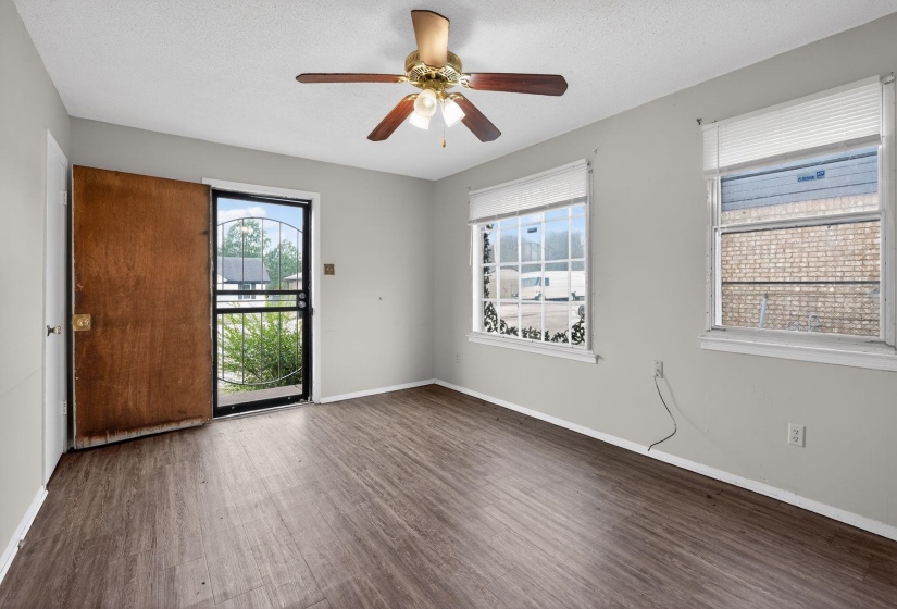 Unfurnished room with dark wood-style flooring, a textured ceiling, and a ceiling fan