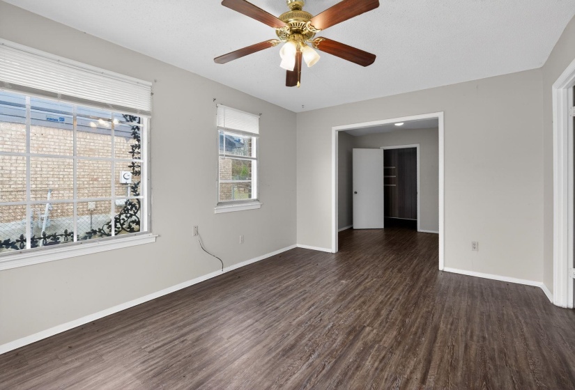 Empty room with dark wood finished floors and a ceiling fan