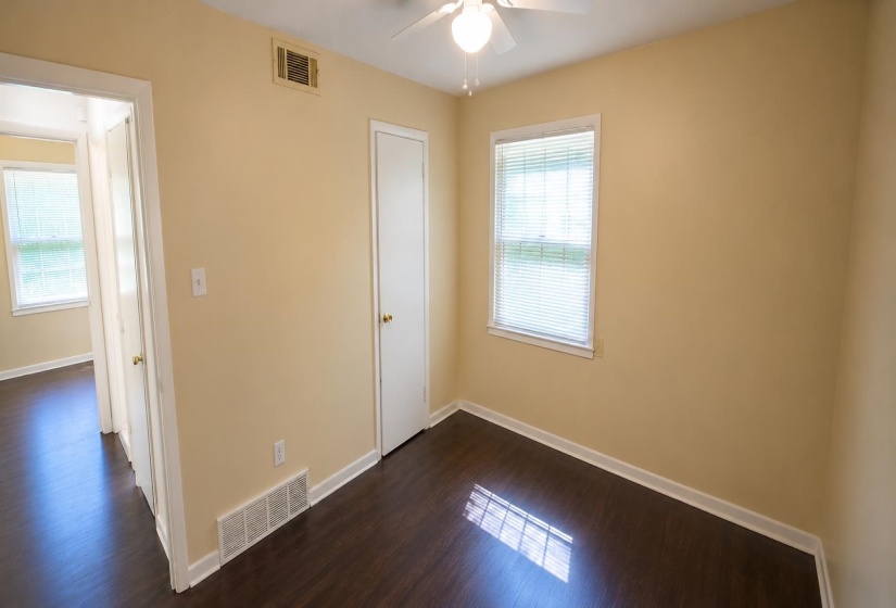 Room with wood-finish flooring, neutral wall tones, and white trim