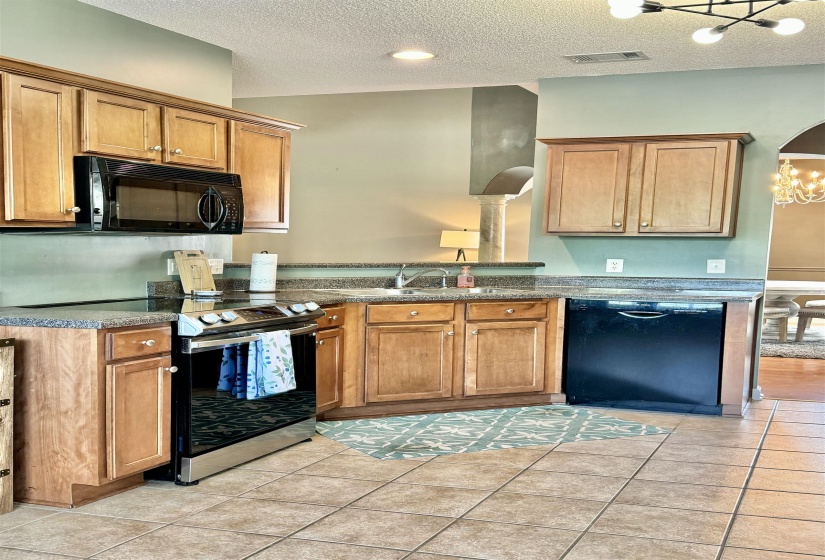 Kitchen featuring wood cabinetry, stone-finish countertops, and tile flooring