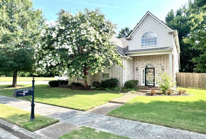 Cream brick exterior featuring white siding accents and an arched transom window