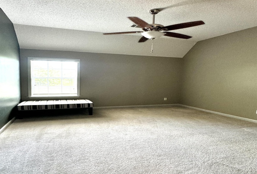 Room featuring vaulted ceilings, a ceiling fan with light fixture, carpeted flooring, and a window with blinds