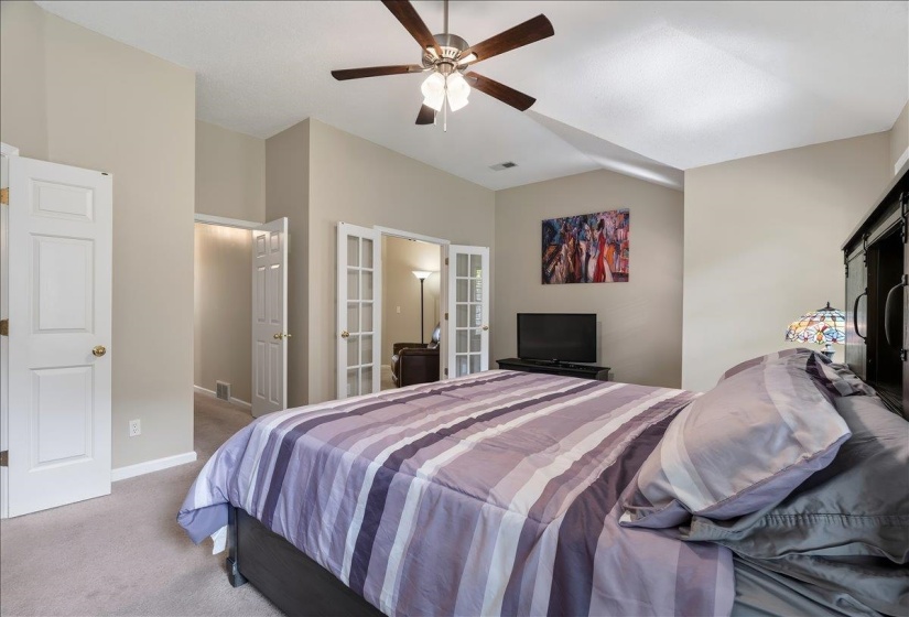 Vaulted ceiling bedroom featuring soft neutral wall tones and carpet flooring