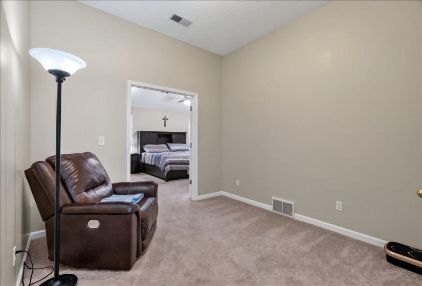 Carpeted room with vaulted ceiling and neutral wall tones