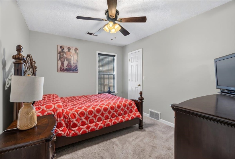 Neutral wall paint, carpeted flooring, window with blinds, ceiling fan, and white door with paneled design