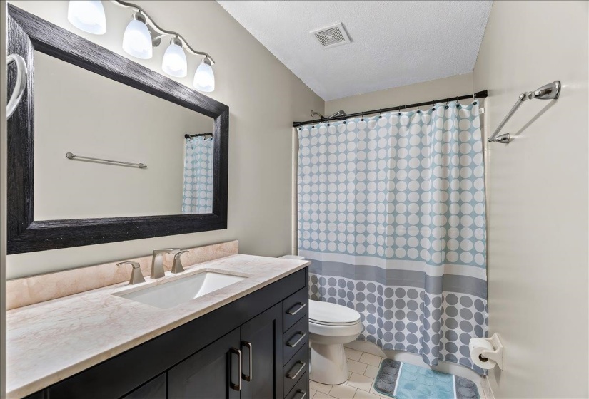 Bathroom vanity with a rectangular undermount sink and brushed nickel faucet