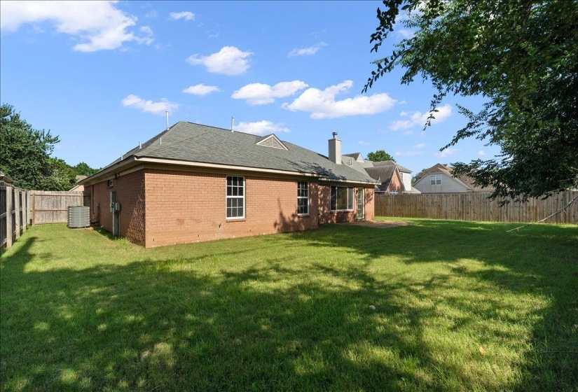 Expansive grass lawn with complete wood privacy fencing