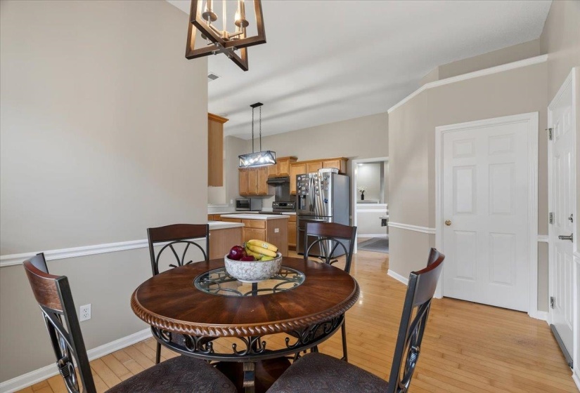 Dining area with wood-finish flooring and a contemporary chandelier