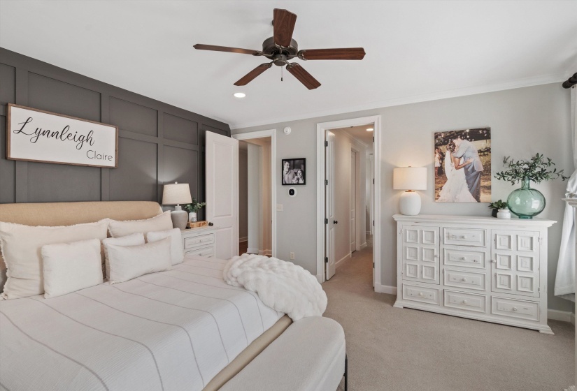 Neutral-toned bedroom featuring a dark accent wall with paneling