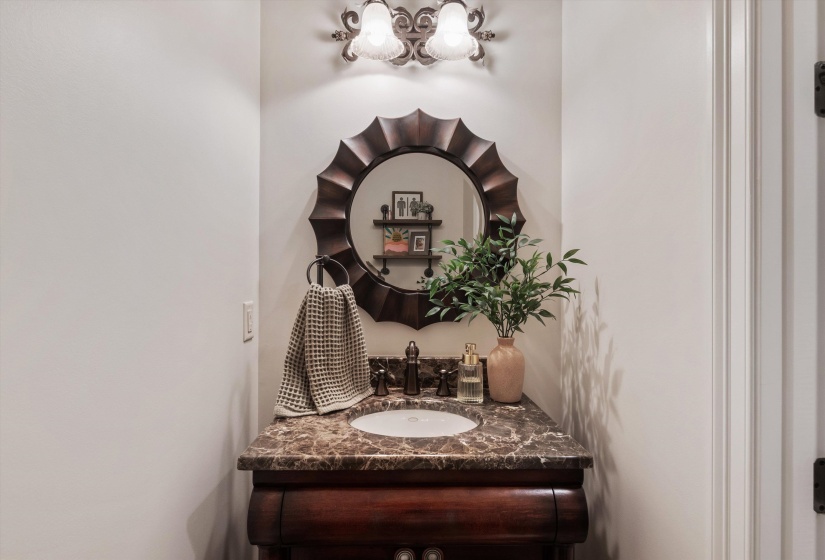 Pedestal vanity featuring a dark wood finish, a marble countertop, and an integrated white basin