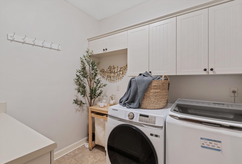 Dedicated laundry area featuring abundant white shaker-style cabinetry with dark hardware