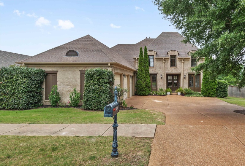 Traditional-style residence featuring a brick facade, multi-gabled roofline, and dormer windows