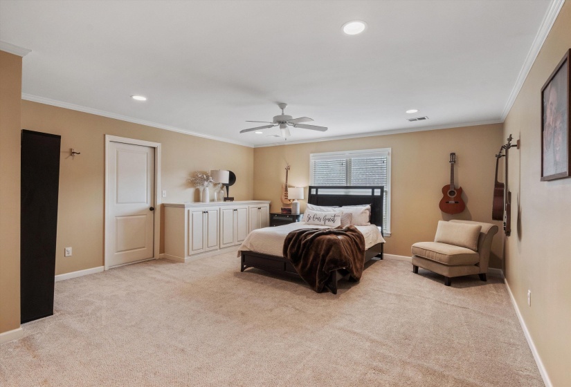 Carpeted room with recessed lighting, crown molding, a ceiling fan, white paneled door, and built-in white cabinetry with a light-toned countertop