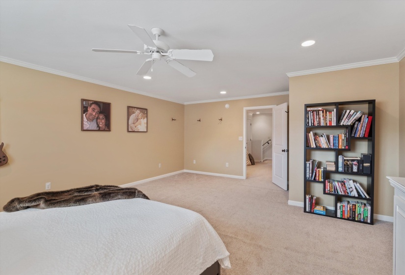 Spacious room featuring neutral carpeting, crown molding, a ceiling fan, and recessed lighting