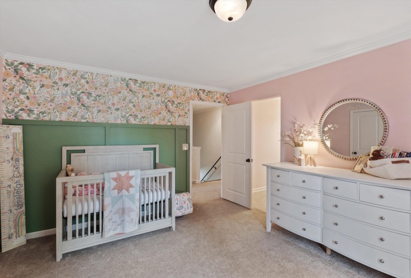 Carpeted room featuring a white ceiling, crown molding, and a flush mount light fixture