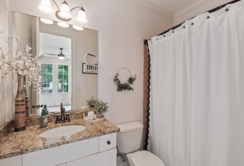 Bathroom vanity with a granite countertop, undermount sink, and bronze-finish faucet