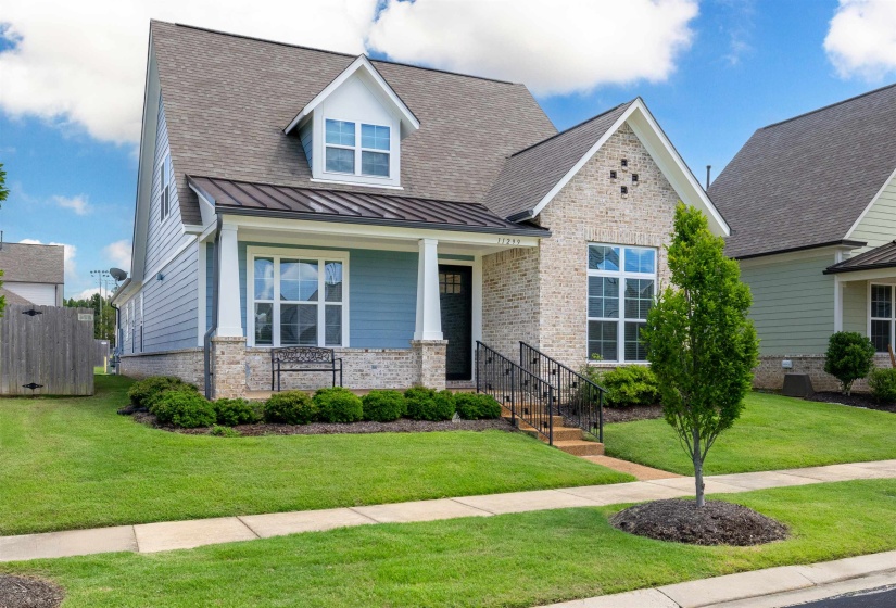 Craftsman-style exterior featuring a combination of light-colored brick and blue horizontal siding