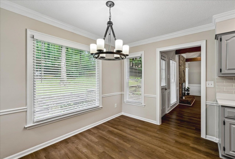 Dining area featuring a contemporary chandelier, wood-finish flooring, and crown molding