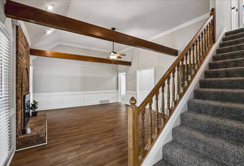Living space featuring a vaulted ceiling with exposed wood beams and recessed lighting