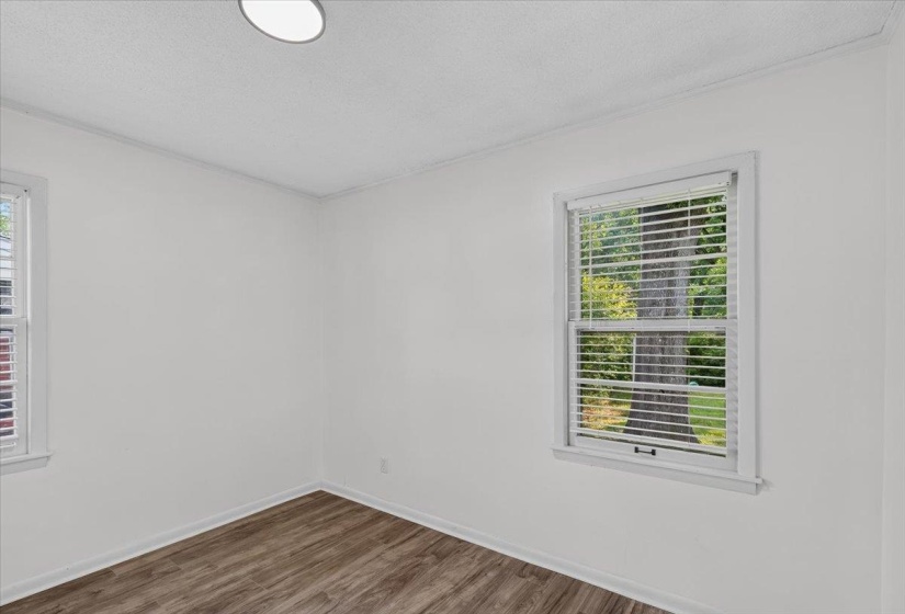 Interior room featuring wood-finish flooring, white walls, and white trim