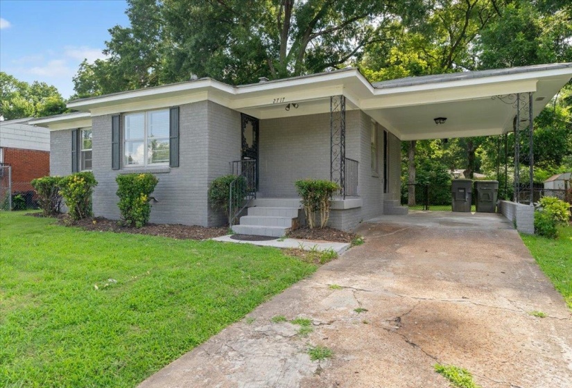 Brick exterior with a carport and concrete driveway