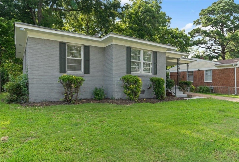 Gray brick exterior featuring white trim and dark window shutters