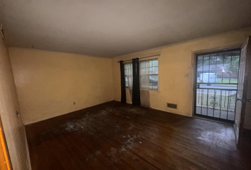 Hardwood-style flooring extends throughout this room, complemented by a front entry door with an ornate security screen