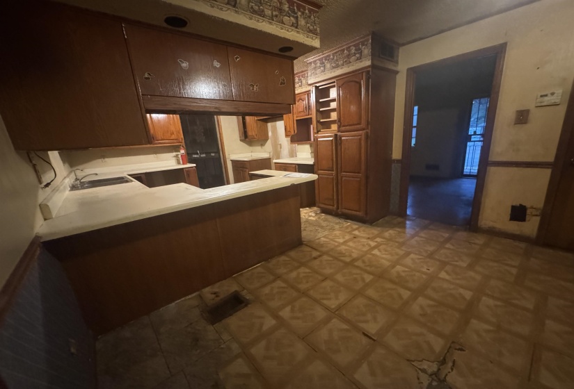 Kitchen featuring wood-finish cabinetry, light-toned countertops, and a built-in sink