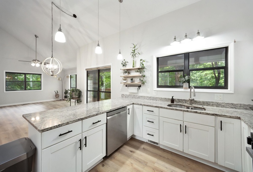 Expansive kitchen featuring white cabinetry, light-toned countertops, and stainless steel appliances